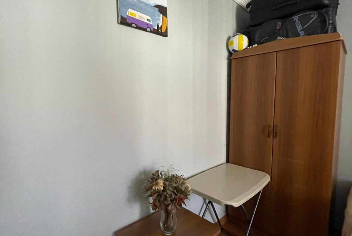 Küçük bir oda, masa ve dolap.